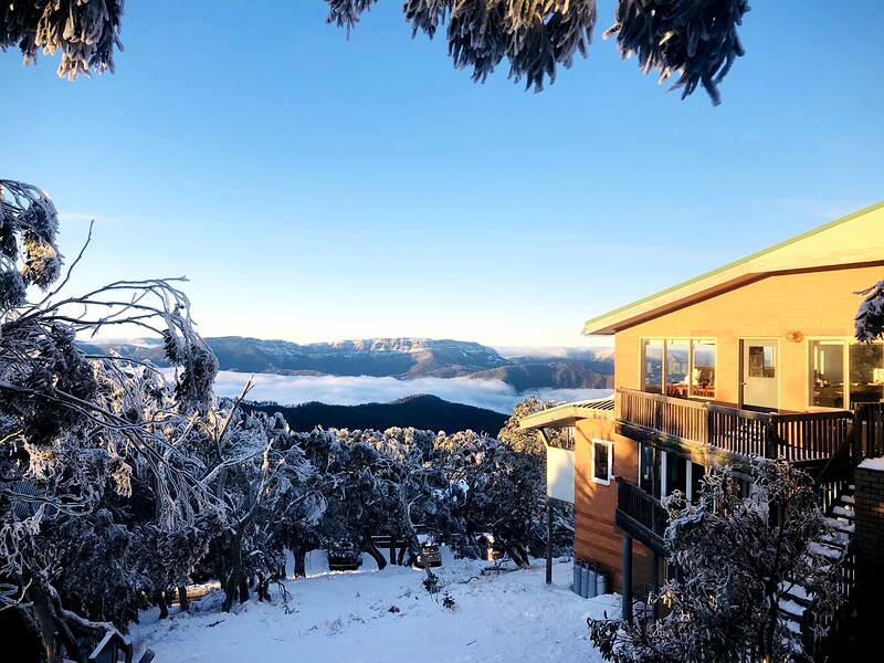First light from the lodge: frosted trees in the foreground and a sea of cloud filling the valley below.